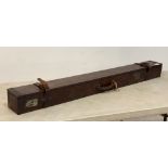 An early 20th century tin bound mahogany fishing rod box, with leather straps and buckles and