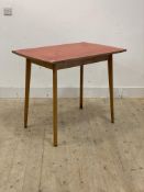 A mid century kitchen table, the red formica top raised on light beech splayed and tapered supports,