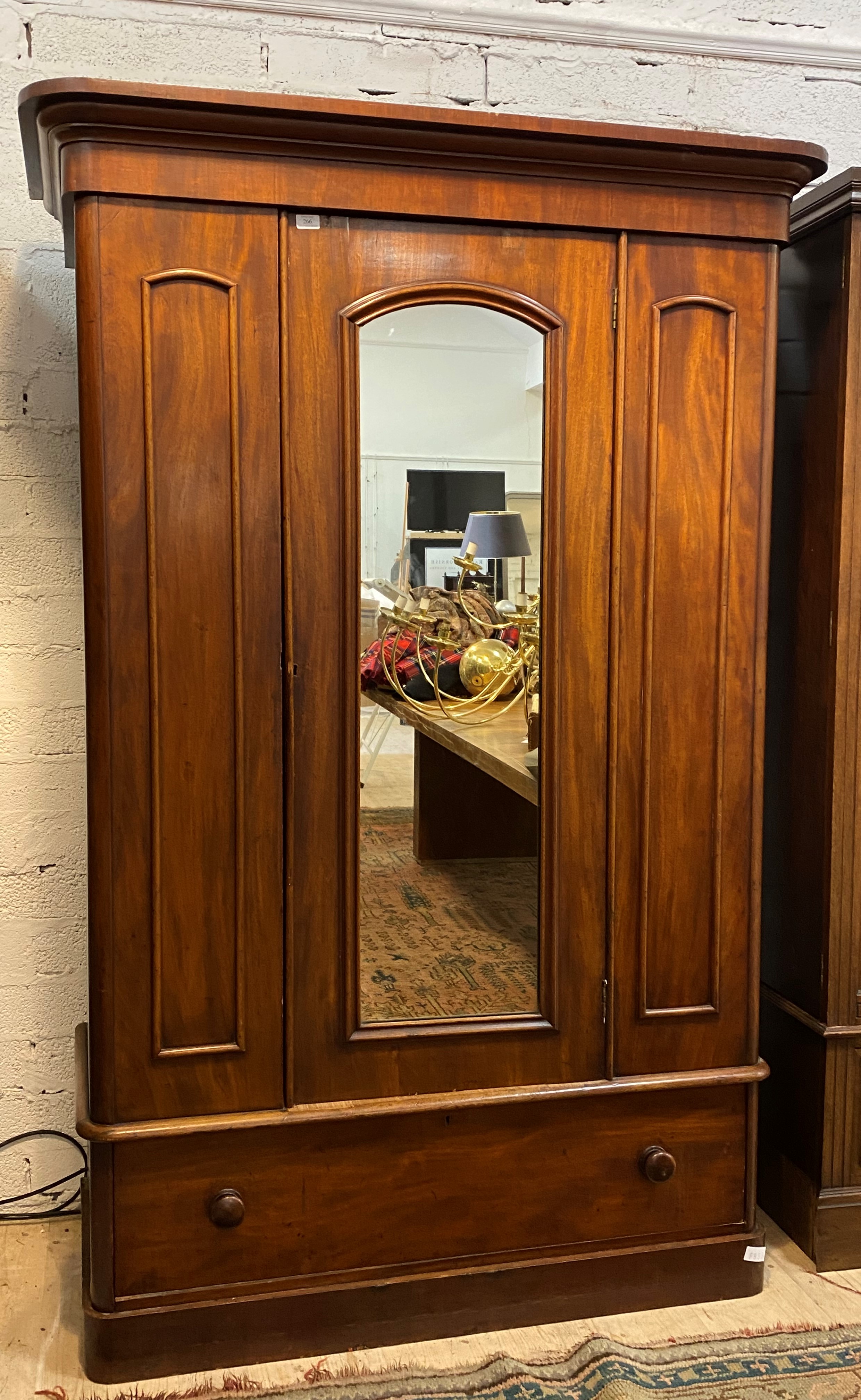 A Victorian mahogany wardrobe, the projecting cornice over arched glazed mirror door enclosing