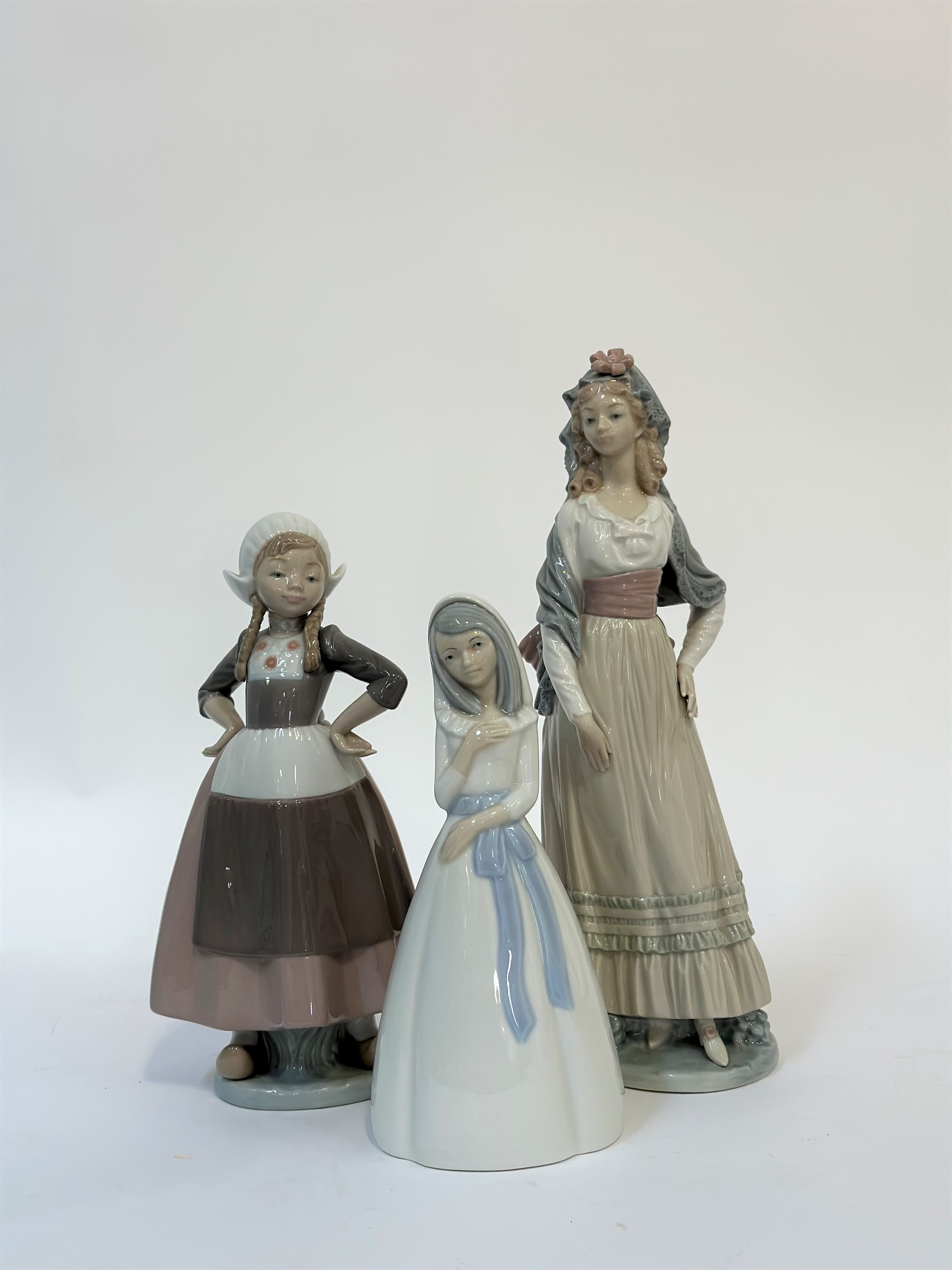 A Lladro figure of a Dutch girl with arms, a Lladro figure of a Goya lady (h-32cm) and a Miquel