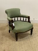 A late Victorian tub chair, the upholstered crest rail and arm rest on a spindle gallery, all