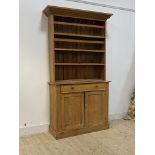 A Victorian country pine dresser, the projecting cornice over three height plate rack, above a