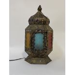 A Moroccan style table light in the form of an octagonal hanging lantern, the openwork gilt metal