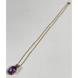A 14ct gold mounted oval amethyst pendant in claw setting, on fine yellow metal trace link chain