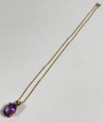 A 14ct gold mounted oval amethyst pendant in claw setting, on fine yellow metal trace link chain