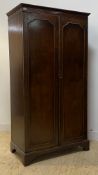 An early 20th century mahogany wardrobe, the twin panelled doors enclosing an interior fitted for