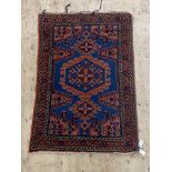 A Persian Hamadan hand knotted rug, the blue field with typical design and bordered 157cm x 104cm