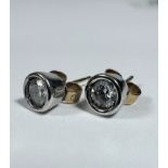 A pair of Diamond white gold mounted stud earrings, each stone approximately 0.25ct, in rub over