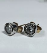 A pair of Diamond white gold mounted stud earrings, each stone approximately 0.25ct, in rub over