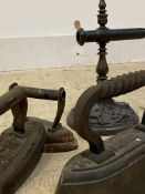 A collection of three Victorian cast iron flat irons, and an iron stand (4)