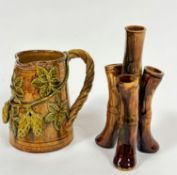 An Edwardian pottery jug with rope pattern scroll handle to side and applied fruit and leaf