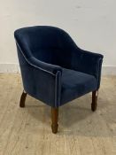 An early 20th century tub chair, upholstered in clean blue velvet, raised on walnut square tapered