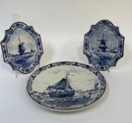 A trio of Delft wall hanging decorative plates, a pair depicting a Holland windmill scene and the