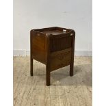 A George III mahogany night commode or bedside table, the tray top with pierced handles over tambour