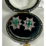 A pair of white metal emerald and diamond cluster earrings, emeralds approximately 0.20ct, with