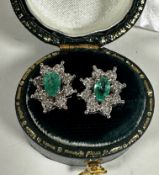 A pair of white metal emerald and diamond cluster earrings, emeralds approximately 0.20ct, with
