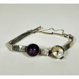 A 9ct white gold flexible graduated link bracelet mounted with purple star sapphire, bracelet a/