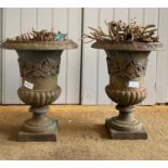 A pair of cast iron urns of campagna form, with egg and dart moulded flared rim over floral cast and