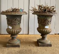 A pair of cast iron urns of campagna form, with egg and dart moulded flared rim over floral cast and