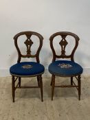A pair of Victorian Aesthetic style walnut side chairs, the circular needlepoint seat worked in a