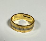 An unusual 18ct gold ribbed wedding band with central white gold stripe, (J) (4.45g)