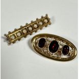 A 9ct gold oval brooch set three graduated oval garnets, mounted in rub over setting, enclosed