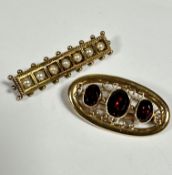 A 9ct gold oval brooch set three graduated oval garnets, mounted in rub over setting, enclosed