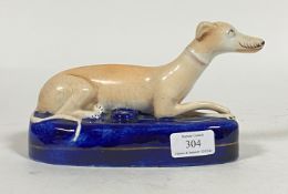 A 19th century Staffordshire lead glazed earthenware penholder, modelled as a recumbent greyhound,