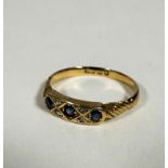 An Edwardian 18ct gold three stone diamond ring set four rose cut diamond spacers, with engraved