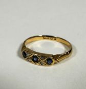 An Edwardian 18ct gold three stone diamond ring set four rose cut diamond spacers, with engraved