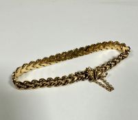 A 9ct gold flat chain link bracelet complete with clasp fastening and safety chain, (d: 9cm) (10.