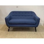 A contemporary two seat sofa, upholstered in buttoned deep blue wool, raised on ebonised turned
