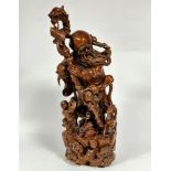 A Chinese carved Rootwood figure modelled as a wise man with dragon carved staff and carrying a