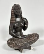 A mid century pottery seated Asian figure draped with headdress and sarong style skirt, with white