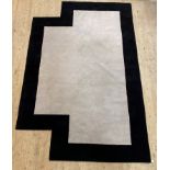 A contemporary rug of geometric form, the ivory field enclosed by a contrasting border 383cm x