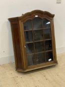 An early 20th century glazed walnut wall hanging cabinet, the door opening to three shelves,