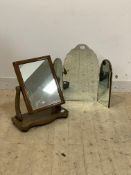 A Victorian mahogany swing mirror, the rectangular mirror swivelling between scrolled uprights, (