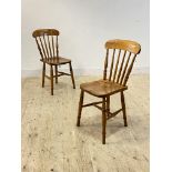 A pair of late 19th century farmhouse chairs, probably sycamore, with spindle back over saddle seat,