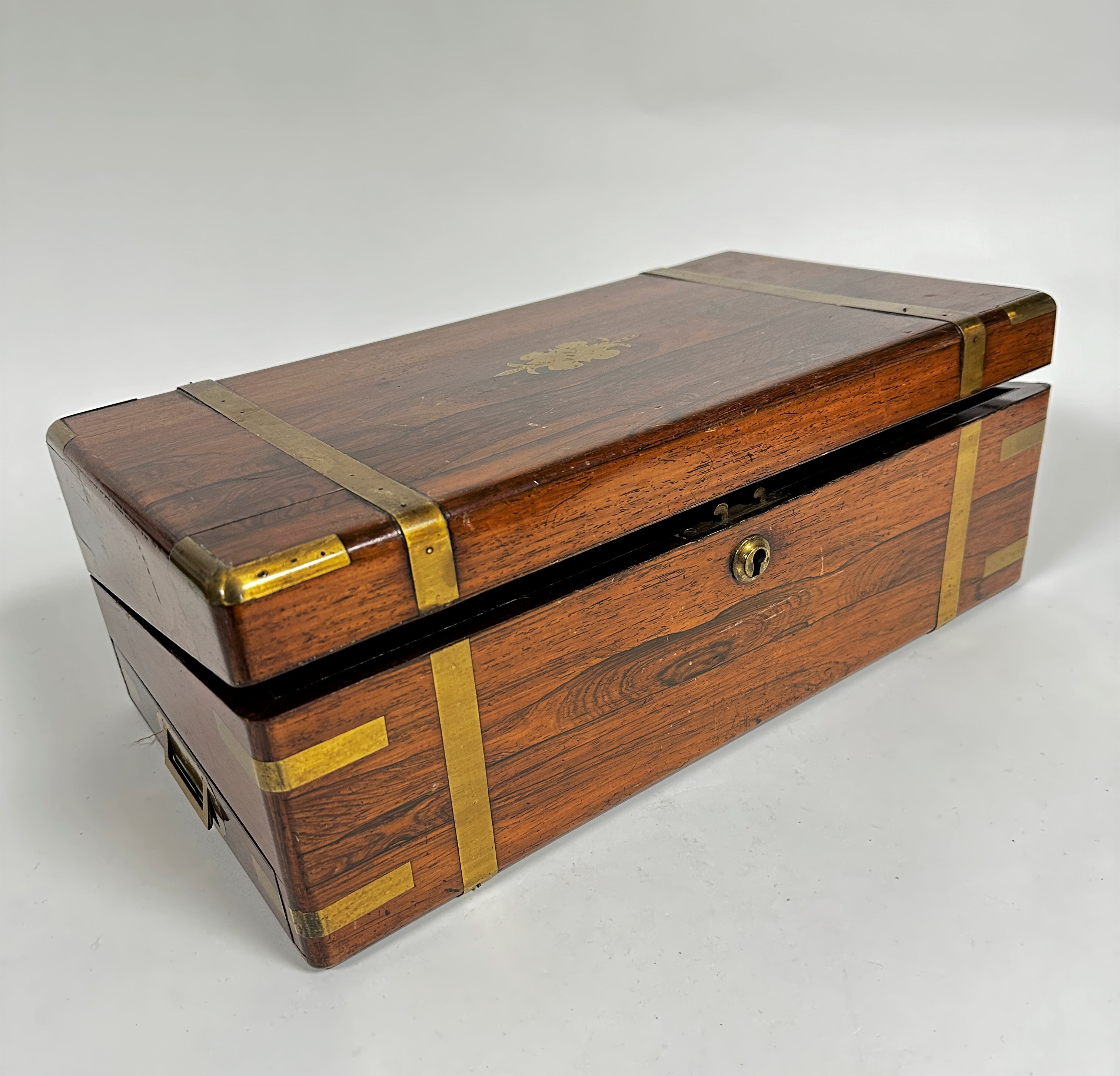 A 19thc rosewood brass bound box desk the rectangular top with rounded angles enclosing a fitted