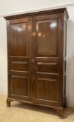 A 19th century mahogany combination press wardrobe the dentil cornice over twin panelled doors,