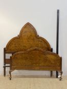 An early 20th century Gothic revival figured walnut 4'6" double bed, complete with side irons,