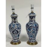A pair of ceramic lamps in baluster form decorated with persian style floral displays raised on a