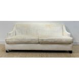 A contemporary high back sofa, upholstered in ivory velure, raised on ebonised bracket supports,