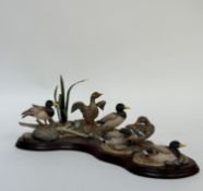 A Border Fine Arts figure of six mallard ducks in various positions on a pebbled bank. (loss to