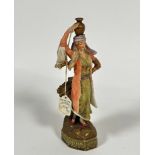 A Continental 19thc porcelain figure of a woman in Eastern costume with water vessel on her head,