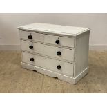 A Victorian white painted pine chest of two short and two long drawers, raised on a shaped plinth
