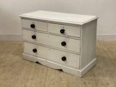 A Victorian white painted pine chest of two short and two long drawers, raised on a shaped plinth