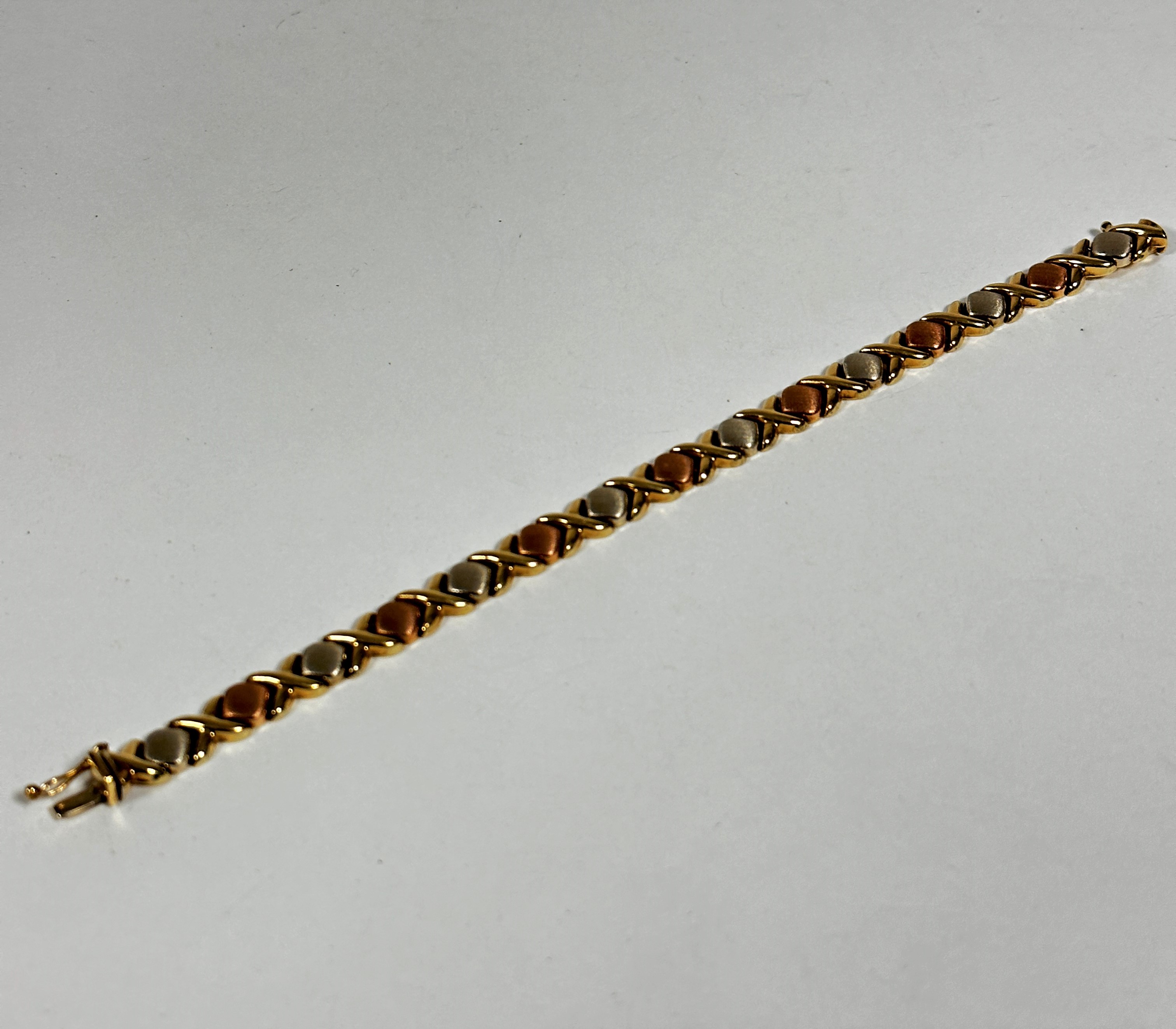 A three coloured 9ct gold bracelet (L: 18.5cm) (10g) shows no signs of damage, restoration or
