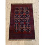 A New Baluchi rug, the red field with gul motif, 133cm x 86cm