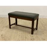 An early 20th century mahogany duet stool or window seat, the top upholstered in green faux leather,
